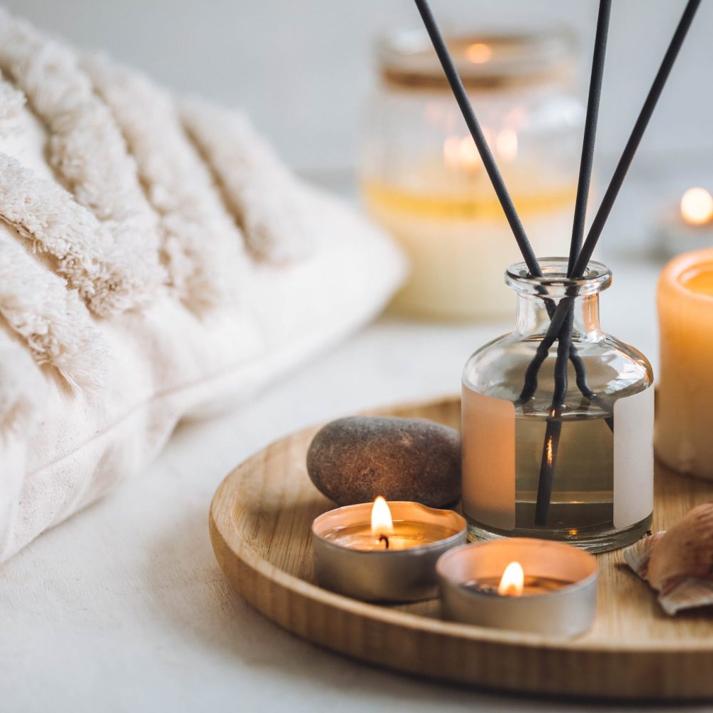 Cozy corner for home meditation and relaxation. Aroma diffuser, burning candles, stones for comfort, pleasure, aromatherapy. Decor for apartment, house, indoors design