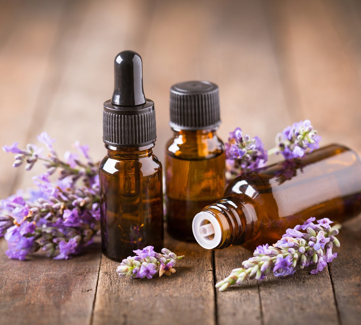Transparent Bottles of essential oil with fresh herbs and flowers, natural treatment for massage, aromatherapy or spa. Natural medicines